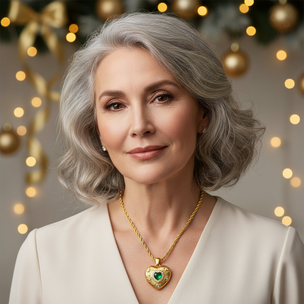 Gold heart-shaped necklace with a green gemstone on a white background