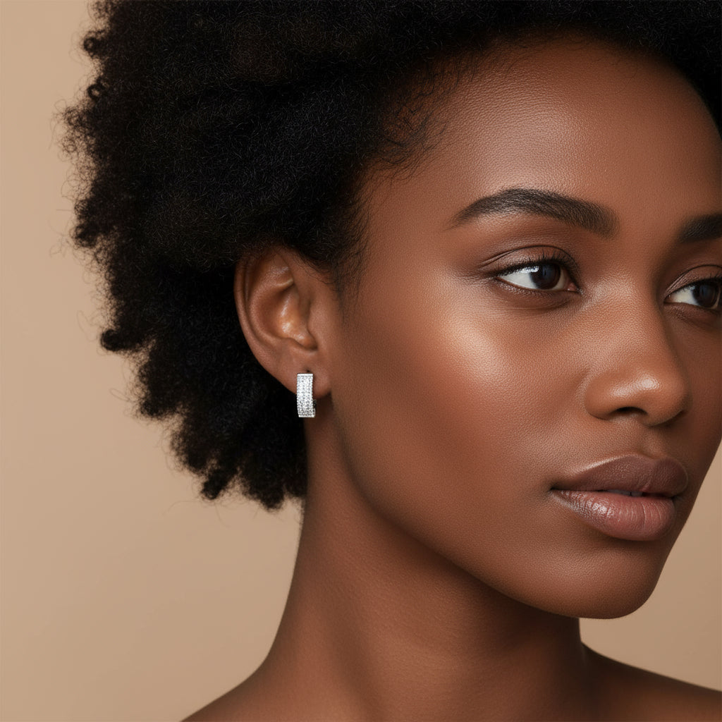 Pair of silver hoop earrings with clear gemstones on a white background