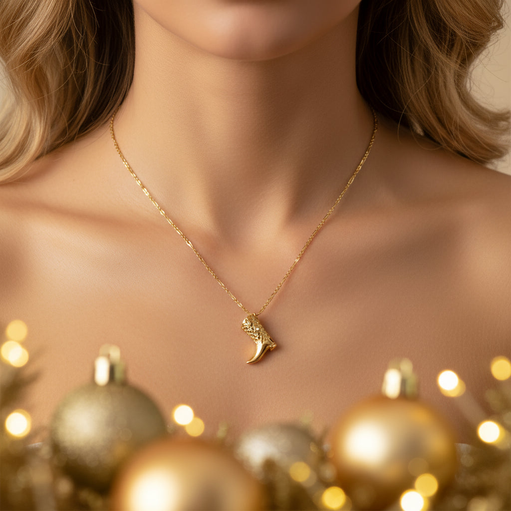 Gold necklace with a decorative pendant on a white background