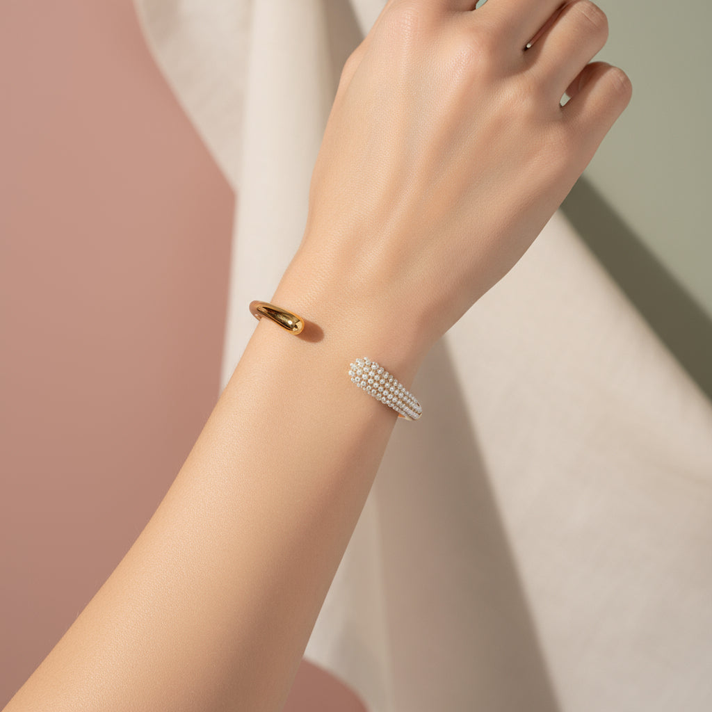 Gold bracelet with pearl detailing and measurements on a white background
